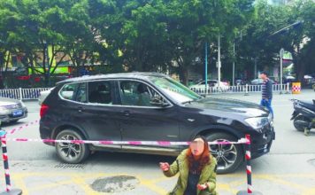 咋回事?女子在街头将自家宝马车砸了 还跪着哭