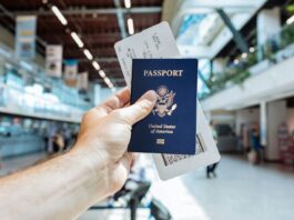 2026 护照办理还要等多久?美国国务院当前页面这几个时间点先记住 机场里旅客手持护照和登机牌准备出行