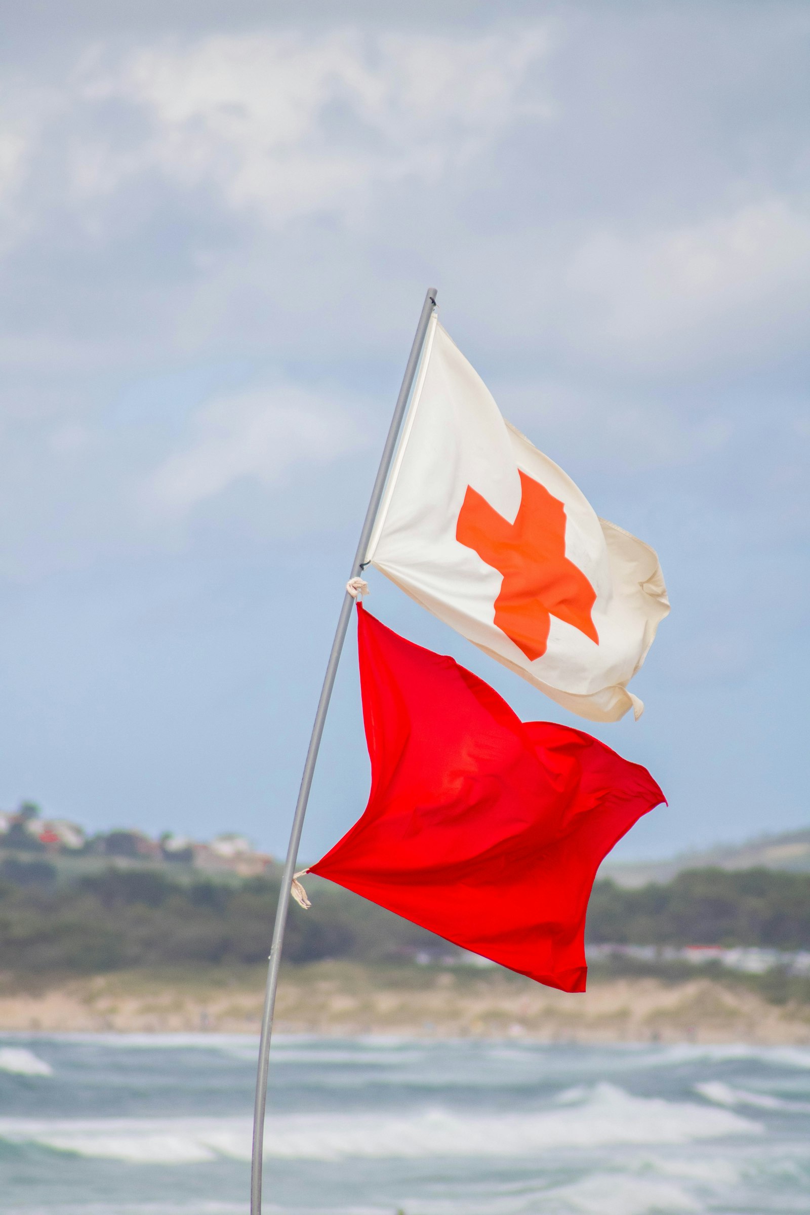 海边红白安全旗在风中飘动提醒游客注意海况