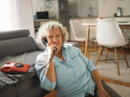 一位老年女性在家接听电话，提醒长者警惕冒充 Medicare 的诈骗来电
