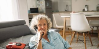 一位老年女性在家接听电话，提醒长者警惕冒充 Medicare 的诈骗来电