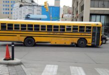开学季校车安全:NHTSA 说校车是最安全的校途方式,但上下车那 10 英尺最危险 美国校车停在市区路口旁、斑马线附近,提醒开学季注意校车与行人安全