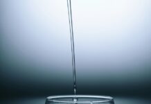 清水正倒入玻璃杯，配图说明环保署拨款培训饮用水与污水处理从业人员
