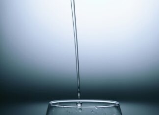 清水正倒入玻璃杯，配图说明环保署拨款培训饮用水与污水处理从业人员